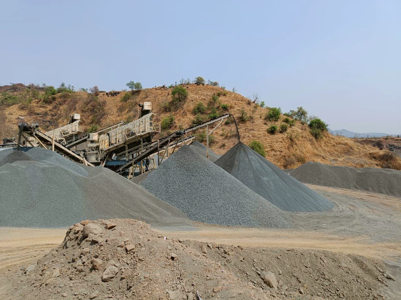 Graded stockpile cones beside the crushing line